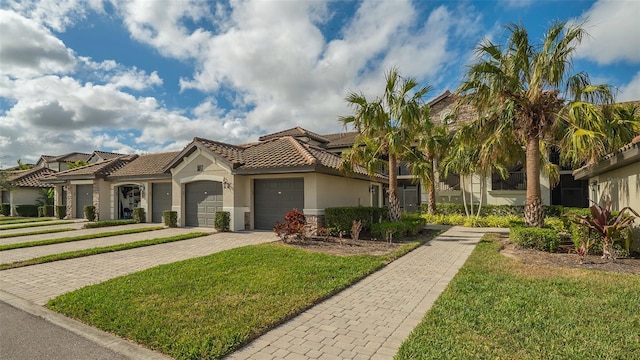 mediterranean / spanish home featuring a front yard and a garage