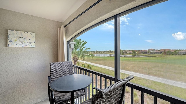 sunroom / solarium featuring a water view