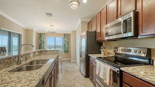 kitchen with a chandelier, appliances with stainless steel finishes, light stone counters, and sink