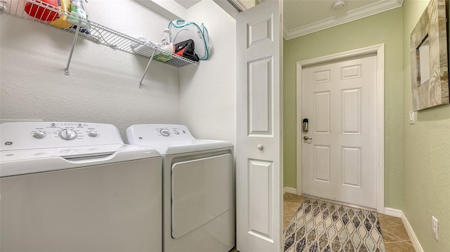 laundry area featuring washer and clothes dryer, light tile patterned flooring, and ornamental molding