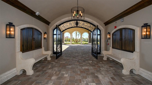 foyer entrance with french doors, vaulted ceiling, and ornamental molding