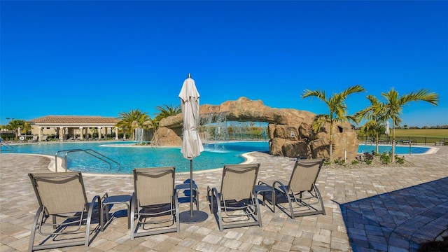 view of swimming pool featuring pool water feature and a patio