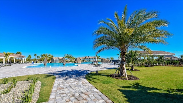 view of pool featuring pool water feature and a yard