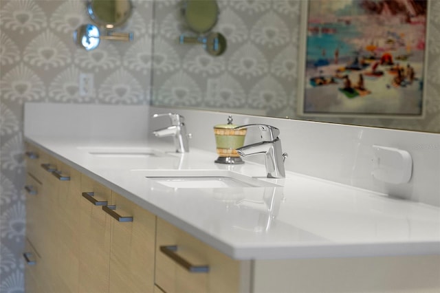 bathroom with wallpapered walls and a sink
