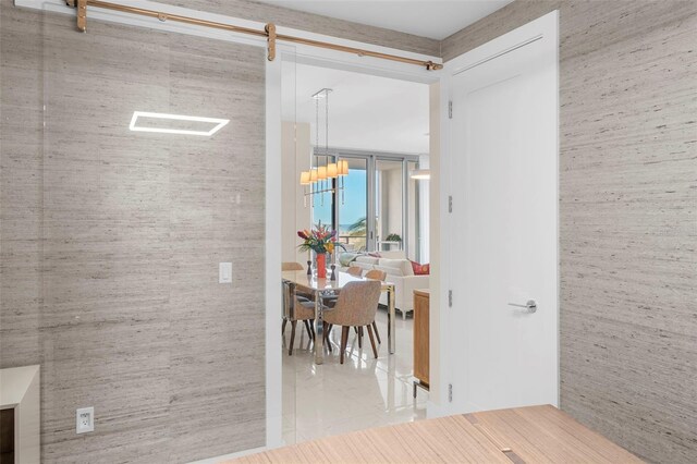 hallway with tile patterned flooring and a barn door