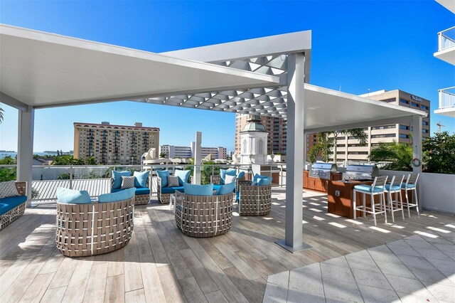 view of patio featuring a deck, exterior bar, a grill, exterior kitchen, and an outdoor living space