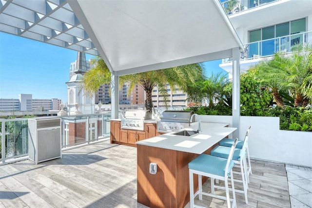 view of patio featuring exterior bar, an outdoor kitchen, and grilling area