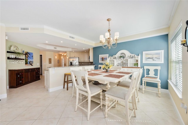 dining space featuring light tile patterned floors, crown molding, sink, and a chandelier