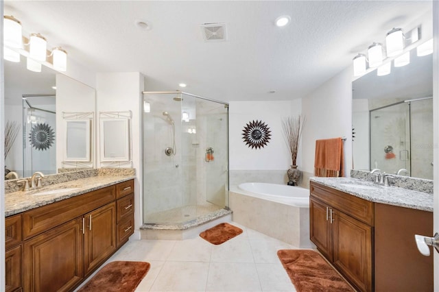 bathroom with tile patterned flooring, vanity, plus walk in shower, and a textured ceiling