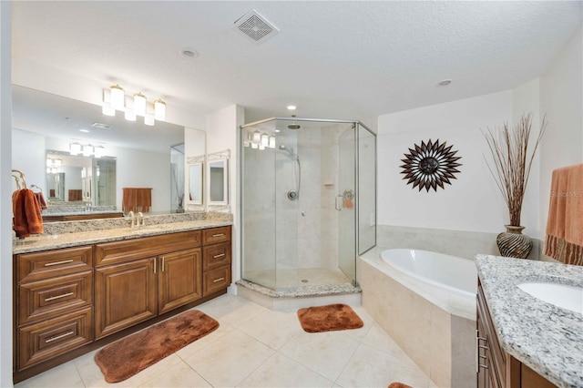 bathroom featuring tile patterned flooring, vanity, separate shower and tub, and a textured ceiling