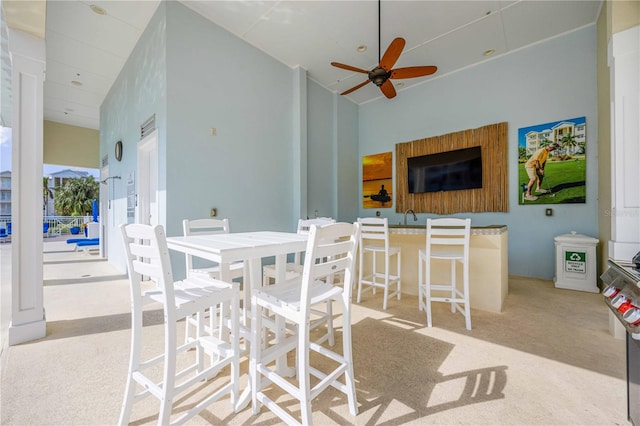 carpeted dining space with ceiling fan