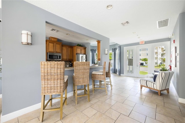 kitchen with appliances with stainless steel finishes, a breakfast bar, plenty of natural light, and kitchen peninsula