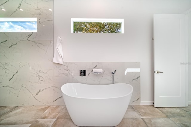 bathroom with a bathing tub and tile walls