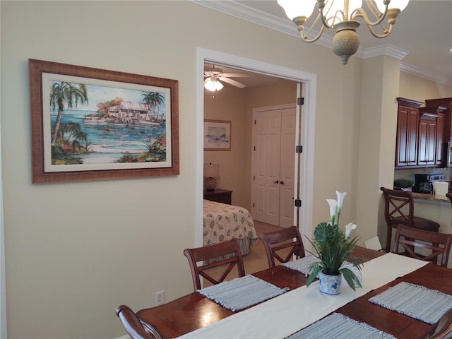 dining room with crown molding and ceiling fan with notable chandelier