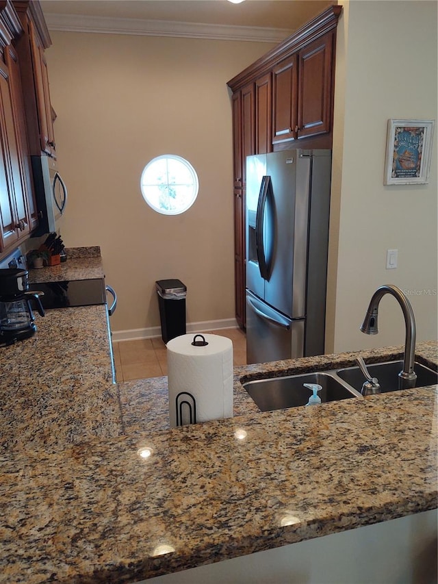 kitchen with light tile patterned floors, light stone countertops, sink, crown molding, and stainless steel appliances