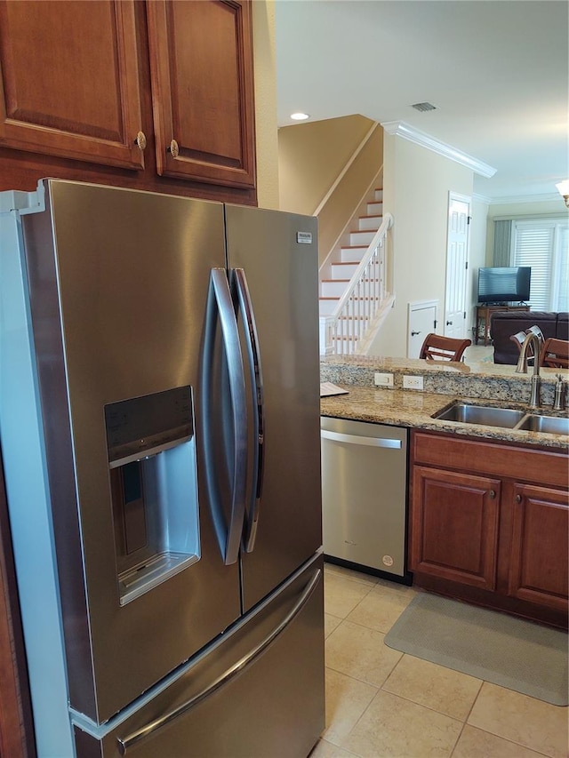 kitchen featuring sink, light stone counters, stainless steel appliances, crown molding, and light tile patterned floors