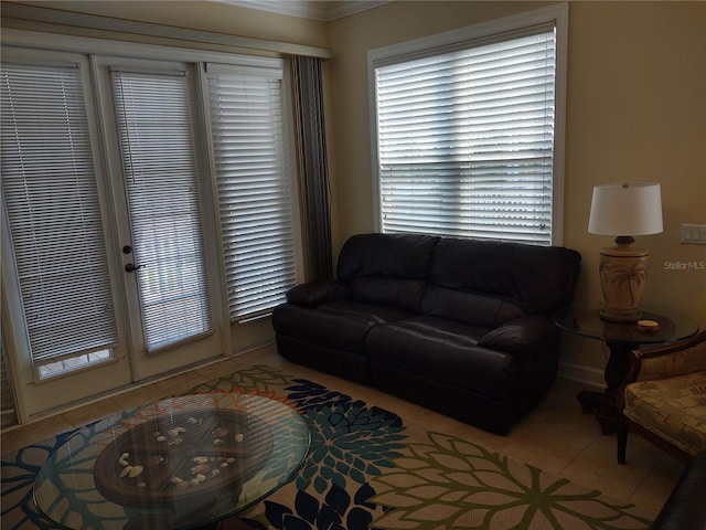 living room with a healthy amount of sunlight, ornamental molding, and tile patterned flooring