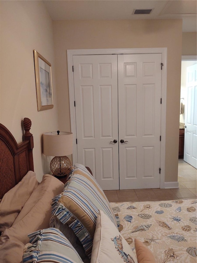 bedroom with a closet and light tile patterned flooring