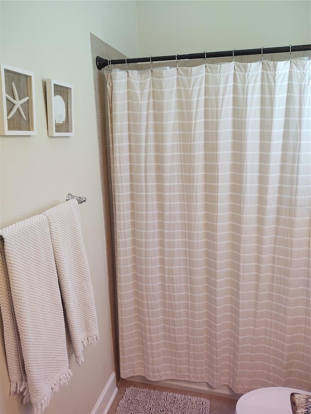 bathroom featuring toilet and curtained shower