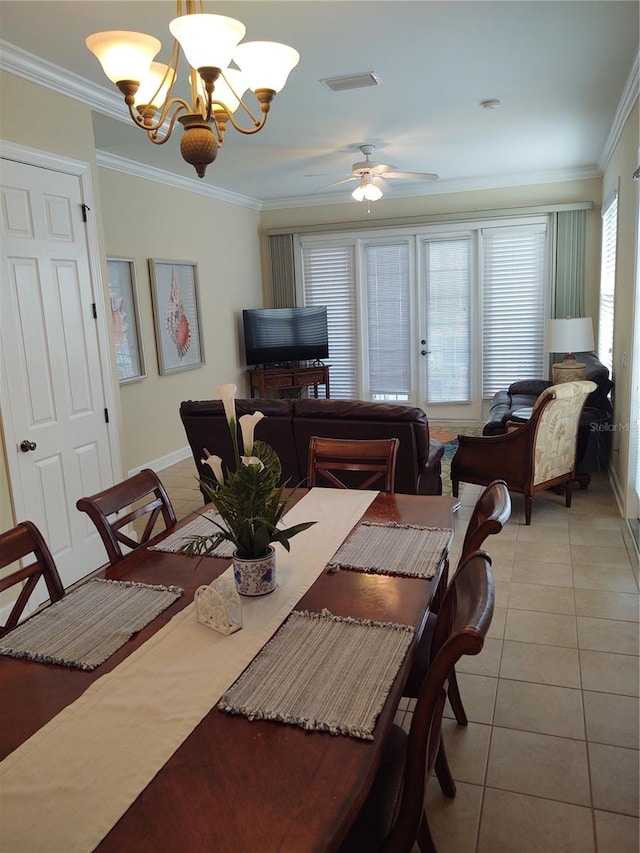 dining area with crown molding, ceiling fan with notable chandelier, a healthy amount of sunlight, and light tile patterned floors