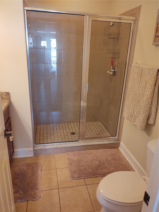 bathroom with toilet, a shower with shower door, vanity, and tile patterned floors