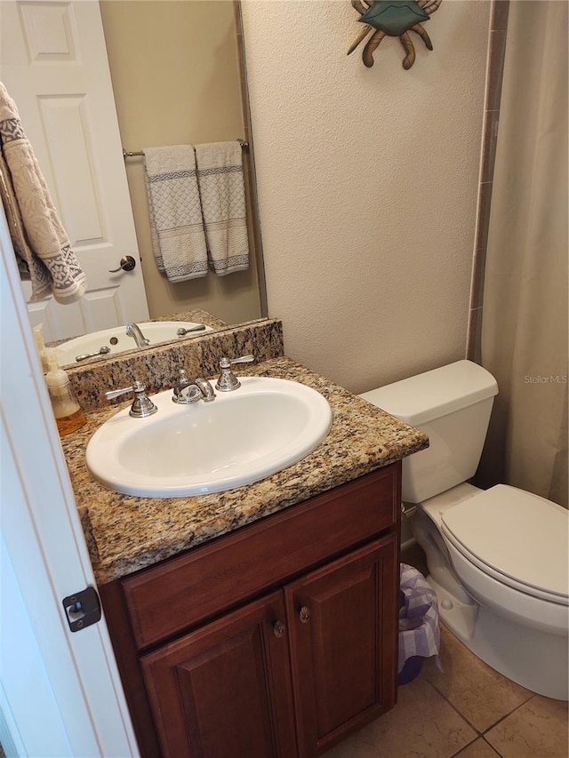 bathroom featuring vanity, toilet, and tile patterned flooring