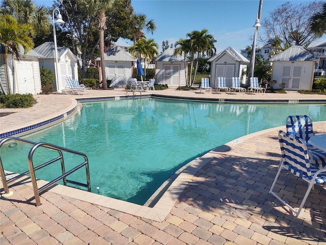 view of swimming pool with a patio and a storage unit