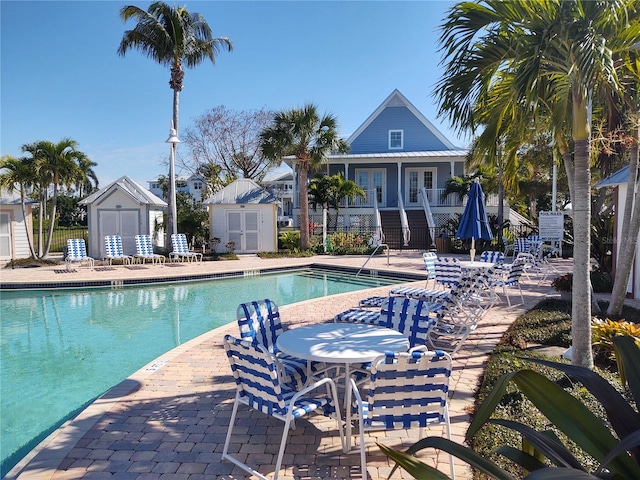 view of pool featuring a shed and a patio