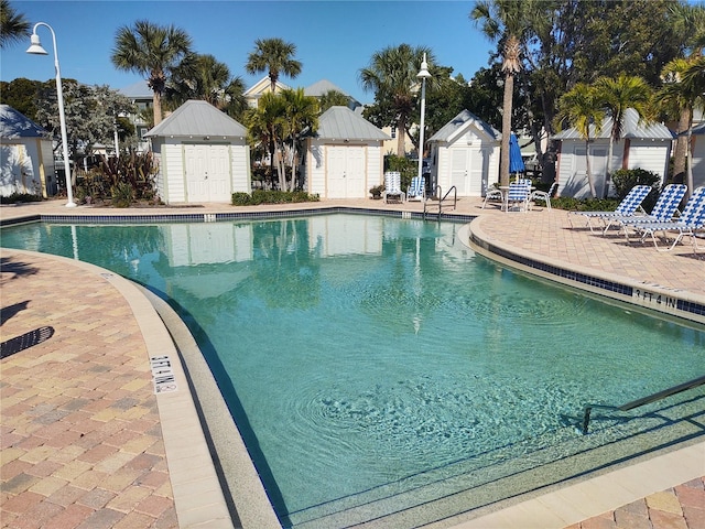 view of swimming pool featuring a patio area and an outbuilding