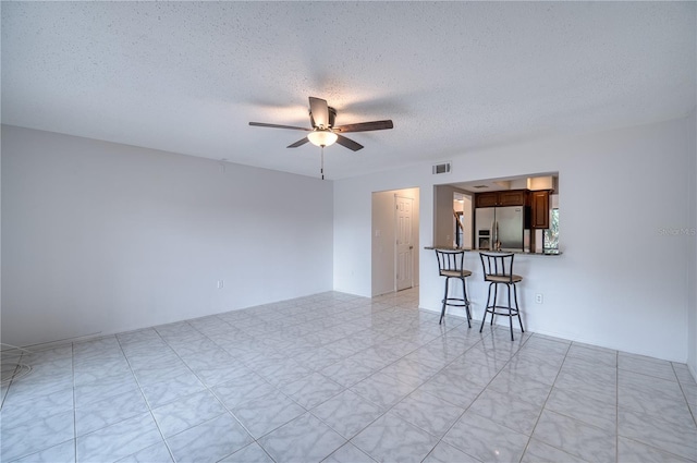 unfurnished room featuring ceiling fan and a textured ceiling