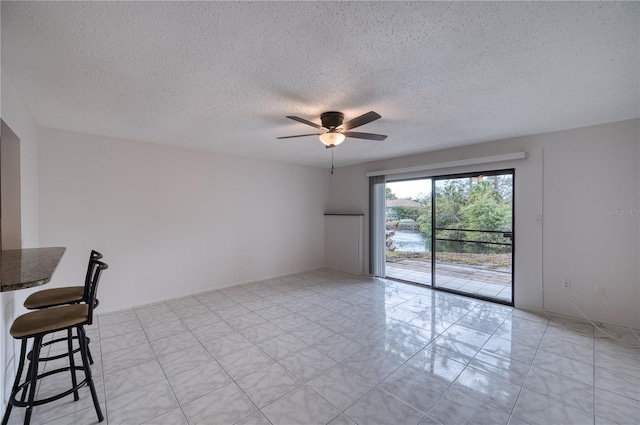 unfurnished room featuring ceiling fan and a textured ceiling