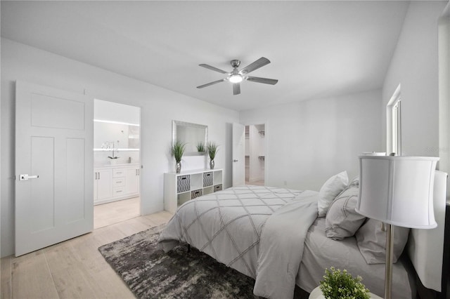 bedroom with light wood-type flooring, ceiling fan, and ensuite bathroom