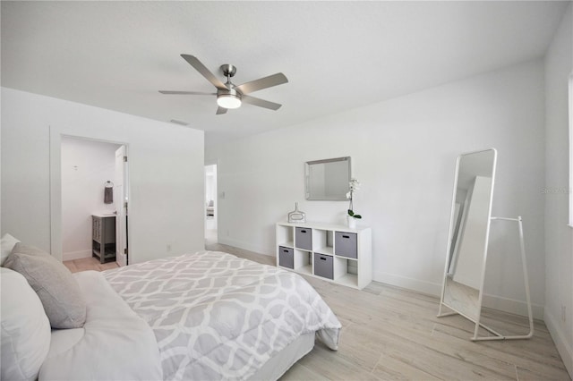 bedroom featuring light wood-type flooring, ceiling fan, and ensuite bathroom