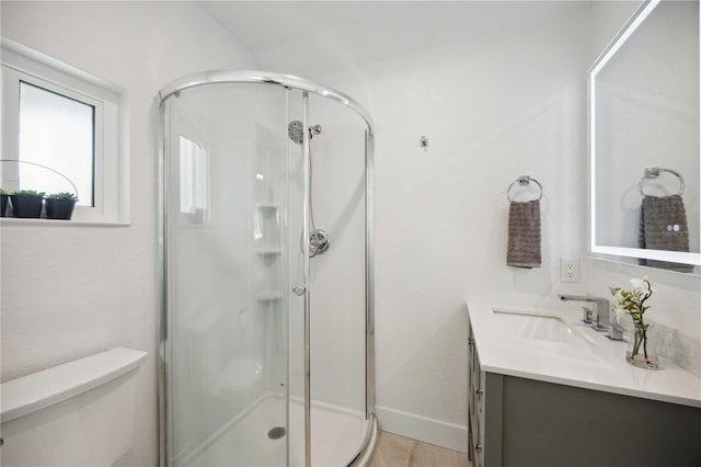 bathroom with hardwood / wood-style flooring, vanity, toilet, and an enclosed shower