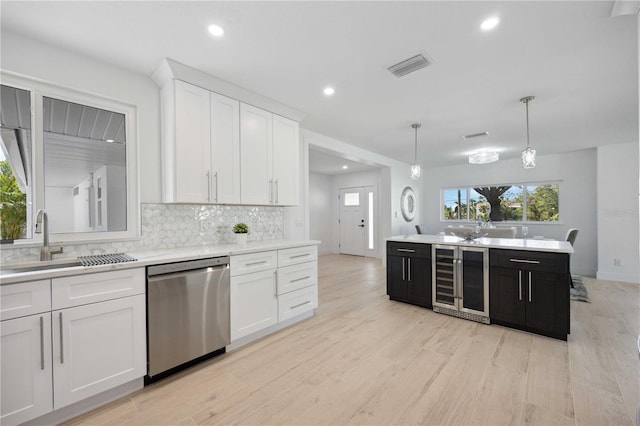 kitchen with white cabinetry, decorative light fixtures, beverage cooler, light hardwood / wood-style floors, and stainless steel dishwasher