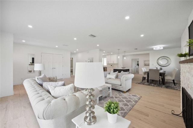 living room featuring light wood-type flooring and a fireplace