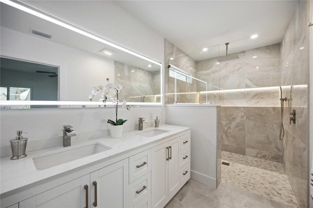 bathroom featuring vanity, tile patterned flooring, and a tile shower