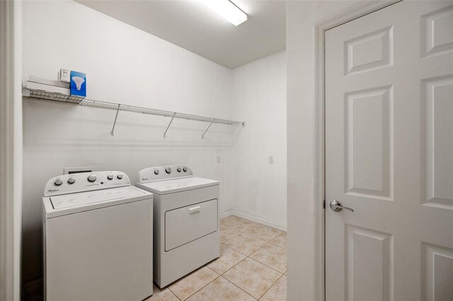 laundry area featuring washer and clothes dryer and light tile patterned floors