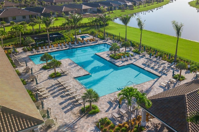 view of swimming pool featuring a patio and a water view