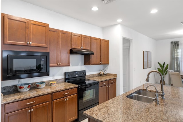 kitchen with black appliances, light stone countertops, and sink