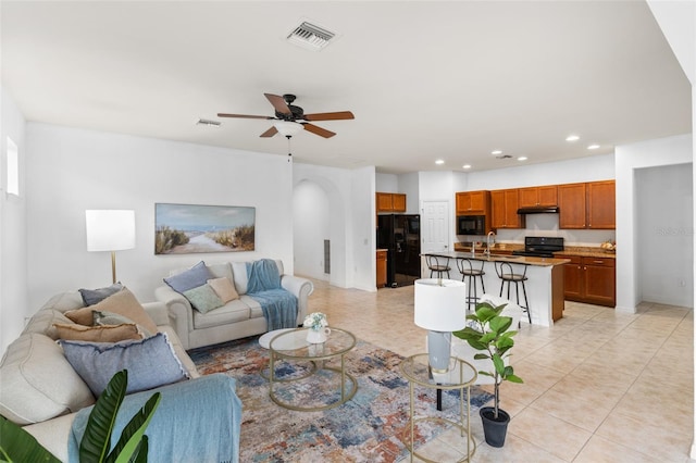 tiled living room with ceiling fan