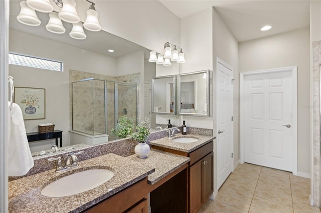 bathroom featuring a shower with shower door, vanity, and tile patterned floors