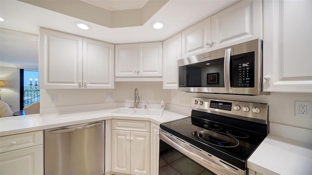 kitchen featuring appliances with stainless steel finishes, white cabinetry, sink, and tile patterned floors