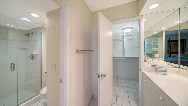 bathroom with vanity, walk in shower, toilet, and tile patterned flooring