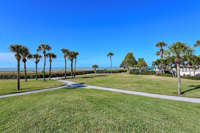 view of property's community with a lawn and a water view