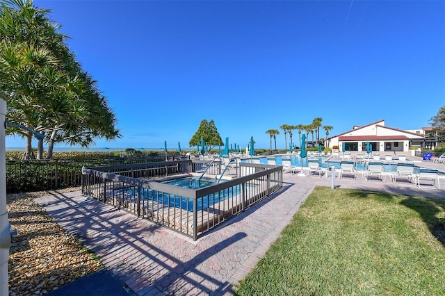 view of swimming pool with a yard, a hot tub, and a patio