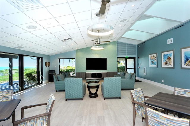 living room with lofted ceiling, a wealth of natural light, and light wood-type flooring