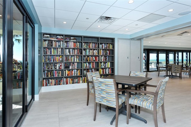 dining room with a drop ceiling and built in shelves