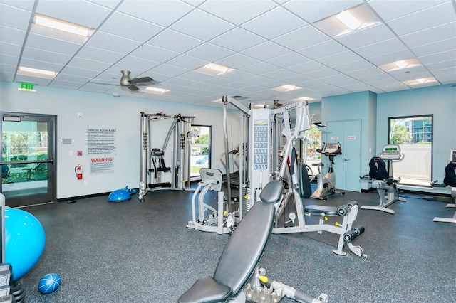 workout area with ceiling fan, a drop ceiling, and plenty of natural light