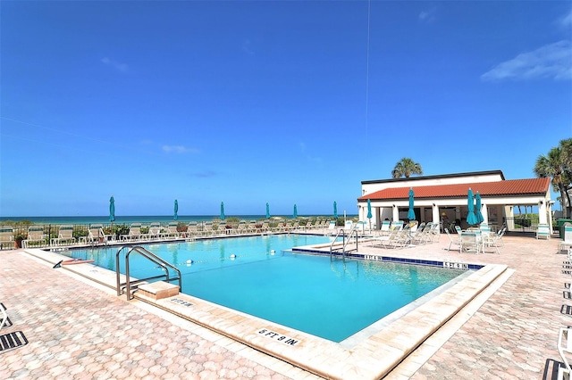 view of pool with a patio and a water view